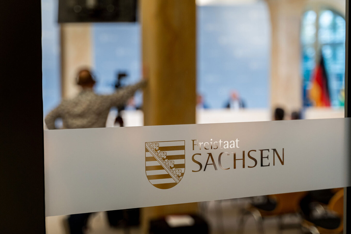 Blick durch eine Milchglastür mit der Aufschrift Sachsen.