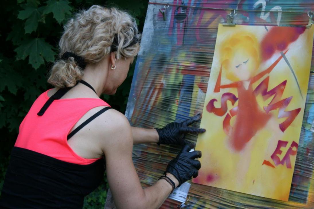 Eine Teilnehmerin der Sommerkunstwoche gestaltet ein Graffiti mit selbst erstellten Schablonen.