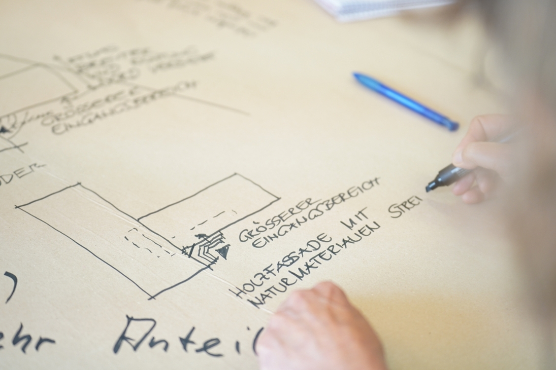 Nahaufnahme von Notizen einer Workshop-Teilnehmerin zum Architekten-Entwurf für den geplanten Neubau.