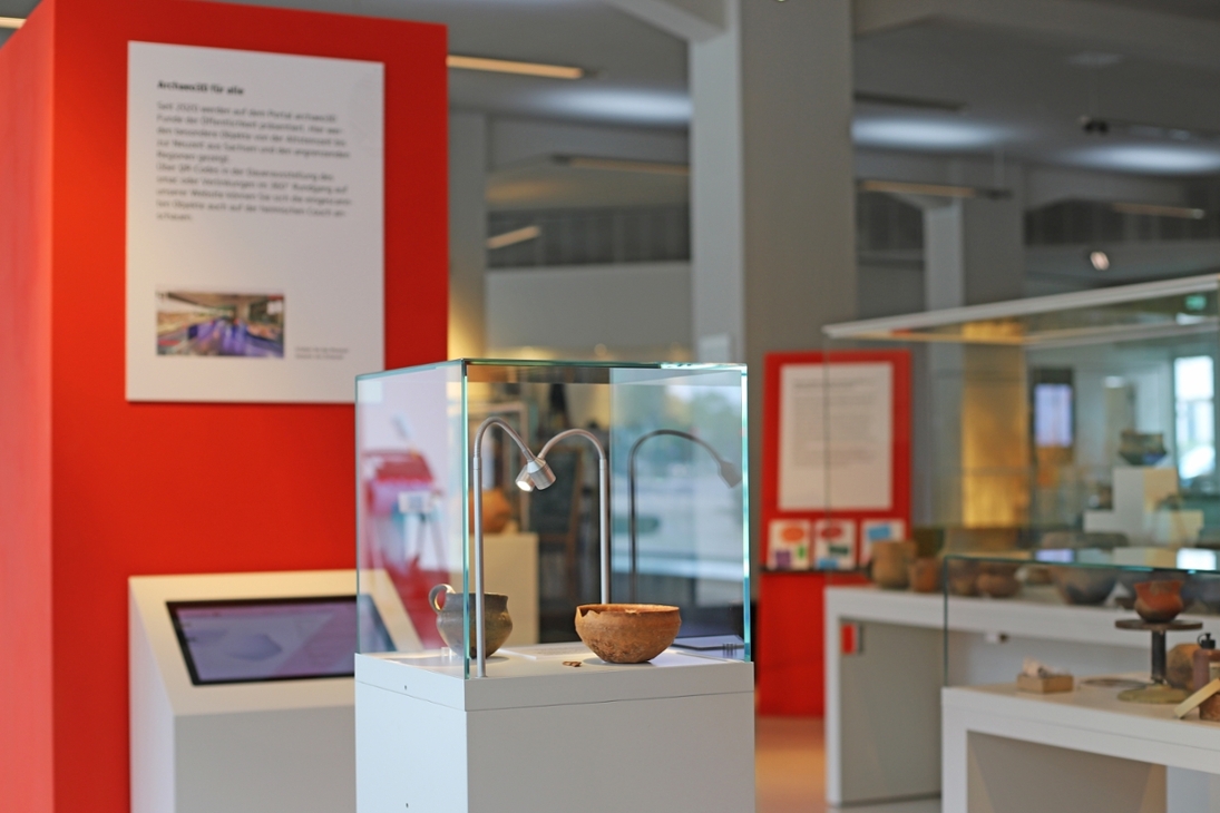 Die Foyerausstellung kombiniert archäologische Objekte mit Medienstationen und Hintergrundinformationen zur Arbeit der Restauratorinnen und Restauratoren.