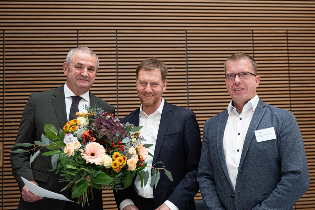 Ministerpräsident Michael Kretschmer und Ralph Beckert, ehrenamtlicher Vorsitzender des Landesbeirats für Inklusion der Menschen mit Behinderungen und Landesgeschäftsführer des VdK Sachsen e. V. gratulieren Michael Welsch, zur Berufung als Landesbeauftragter für Inklusion der Menschen mit Behinderungen. (v.l.n.r.: Michael Welsch, Landesbeauftragter für Inklusion der Menschen mit Behinderungen; Ministerpräsident Kretschmer; Ralph Beckert)