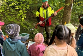 Foto: Forstwirt Mathias Wittwer zeigt den Schülerinnen und Schülern einen Fällheber